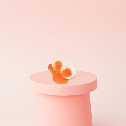 Egg Squishy shaped like a runny sunny-side-up egg with a bright orange yolk.