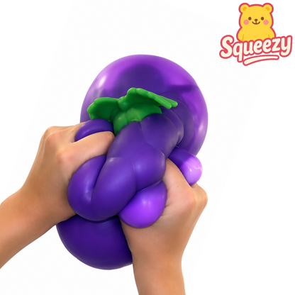 Hands squeezing the Jumbo Grape Squishy showing its ultra soft slow rising foam and realistic grape design