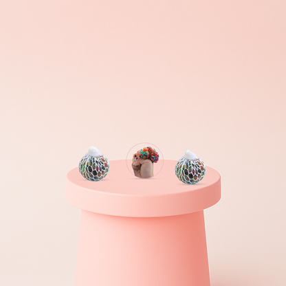 Mesh Ball with Beads being squeezed in a hand, showing colorful bead-filled bubbles expanding through the mesh.
